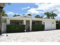 Charming single-story home featuring a manicured lawn, brick driveway, and an attached one car garage at 507 N Peninsula Ave, New Smyrna Beach, FL 32169