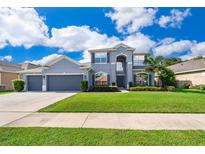 Charming two-story home featuring a manicured lawn and lush landscaping, showcasing curb appeal at 7263 Winding Lake Cir, Oviedo, FL 32765