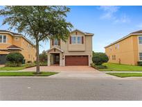 Charming two-story home with a brick driveway and a well-manicured lawn at 7521 Marker Ave, Kissimmee, FL 34747