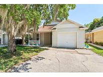 Charming home featuring a one-car garage, well-kept lawn, and inviting front porch at 13146 Odyssey Lake Way, Orlando, FL 32826