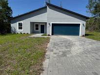 Charming single-story home with a blue garage door and a well-manicured front lawn at 16494 Sw 54Th Court Rd, Ocala, FL 34473