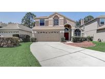 Charming two-story home with a well-manicured lawn and a spacious driveway, perfect for Gathering living at 3539 Foxcroft Cir, Oviedo, FL 32765