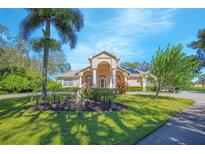Charming single Gathering home with lush landscaping, mature trees, and a welcoming front entrance under a sunny blue sky at 4735 Chelsea Ct, Kissimmee, FL 34744