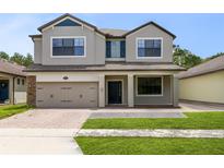Charming two-story home with a manicured lawn, attached two-car garage, and inviting front porch at 5116 Sorrento W Blvd, St Cloud, FL 34771