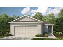 Charming single-story home with a neutral color scheme, a two-car garage, and a well-maintained front yard at 5121 Forget Me Not Ave, Lake Hamilton, FL 33851