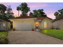 Charming single-story home with a red tile roof, well-manicured lawn, and a two-car garage at 602 Nighthawk Cir, Winter Springs, FL 32708
