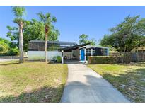 Stylish single-story home featuring a screened-in pool area, charming curb appeal, and lush landscaping at 7712 Hoosier Pl, Orlando, FL 32807
