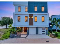 Modern three-story home with a two-car garage, manicured landscaping, and stylish design at 8157 Elion St, Orlando, FL 32827