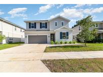 Charming two-story home featuring a well-manicured lawn, attached two-car garage, and tasteful gray exterior at 1073 River Otter Way, Deland, FL 32720