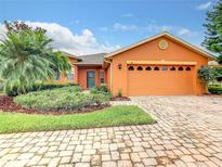 Charming single-story home showcasing a paved driveway, a two-car garage and a well-manicured front yard at 118 Ventana Dr, Poinciana, FL 34759