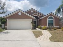 Charming single-story home with a two-car garage, manicured landscaping, and a welcoming front entrance at 340 Haversham Way, Davenport, FL 33897