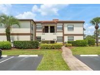 Condominium building exterior with neatly trimmed landscaping and parking at 3475 Flossmoor Ave # 103, Orlando, FL 32822