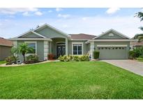 Beautiful single-story home with lush lawn, mature landscaping, and inviting entryway at 3696 Peacepipe Ct, Clermont, FL 34711