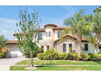 Beautiful two-story home with a turret, tile roof, stone accents and manicured landscaping at 3844 Bowfin Trl, Kissimmee, FL 34746