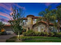 Stately home features a stone turret, tile roof, manicured landscaping, and a side entry two-car garage at 3844 Bowfin Trl, Kissimmee, FL 34746