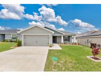 Charming single-story home featuring a well-maintained lawn, a two-car garage and beautiful landscaping at 4270 Swan St, Haines City, FL 33844