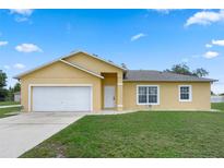 Charming single-story home featuring a two-car garage, well-manicured lawn, and inviting curb appeal at 670 Cotulla Dr, Kissimmee, FL 34758