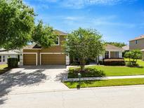 Charming two-story home boasting a well-manicured lawn, mature trees, and a three-car garage at 887 Lancer Cir, Ocoee, FL 34761