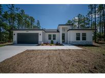 Beautiful single-Gathering home boasting a modern design, manicured lawn, and attached two car garage at 13419 Sw 77Th Ave, Ocala, FL 34473