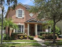 Charming two-story home with a landscaped yard, columns on the porch, and large windows at 14781 Old Thicket Trce, Winter Garden, FL 34787