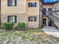 Multi-story townhouse with brick and wood siding plus black trim and staircase leading to the upper levels at 1748 Foxhall Cir # 1748, Kissimmee, FL 34741