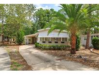 Charming home featuring an enclosed porch with sunshades and a convenient carport at 242 Peppertree Ct, Lake Mary, FL 32746