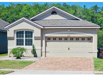 Charming home features a two-car garage, brick driveway, manicured landscaping, and a well-maintained lawn at 2456 Varenna Loop, Kissimmee, FL 34741