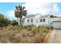 Charming exterior showcasing a two-story home with a quaint front yard and lush landscaping at 330 Phoenix Ave, Daytona Beach, FL 32118