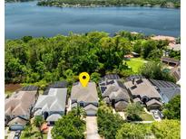 Stunning aerial view of lakefront home with lush green landscaping and solar panels on roof at 334 N Shadowbay Blvd, Longwood, FL 32779