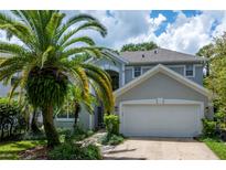 Charming home featuring a well-manicured lawn, tropical palm trees and a two-car garage at 334 N Shadowbay Blvd, Longwood, FL 32779