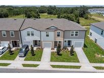 Charming townhomes featuring varied exterior colors, attached garages, and manicured lawns at 3435 Vesara Dr, Davenport, FL 33837