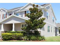 Inviting two-story townhome features a well-manicured lawn, a covered entryway, and neutral tones at 5897 Soter Ln, Windermere, FL 34786