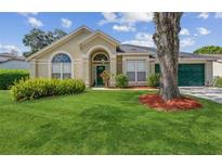 Charming single-story home with well-maintained landscaping, arched windows, and a two-car garage at 1013 Silcox Branch Cir, Oviedo, FL 32765