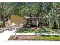 Charming single-story home with a manicured front lawn, mature trees, and a two-car garage at 107 Wayland Cir, Longwood, FL 32779