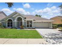 Charming single-story home with well-manicured lawn, paved driveway, and neutral color scheme on a sunny, blue sky day at 1113 Hawthorne Cove Dr, Ocoee, FL 34761