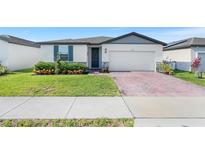 Charming single Gathering home featuring a manicured lawn and welcoming front entrance at 1127 Foreshore Ln, Haines City, FL 33844