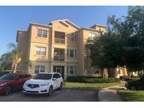 Well maintained tan building with balconies, manicured landscaping, and parking at 120 Terrace Ridge Cir # 120, Davenport, FL 33896