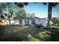 Charming single-story home with manicured lawn, beautiful palms, and attached two-car garage at 1204 Duncan Ct, Longwood, FL 32779