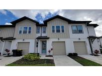 New construction townhome features neutral siding, an attached garage, and manicured landscaping at 1429 Discovery St, Davenport, FL 33896