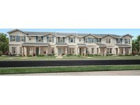Charming townhome showcasing a quaint front porch, blue shutters, and manicured landscaping at 1832 Crowncrest Dr, Apopka, FL 32703