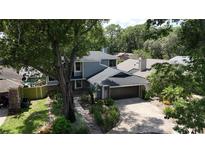 Charming two-story home features a well-manicured lawn, mature trees, and a two-car garage at 208 Frinton Cv, Longwood, FL 32779