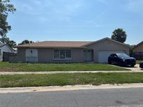Charming single-story home with a well-maintained lawn and a neatly parked car in the driveway at 2087 Allegheny Ct, Orlando, FL 32818