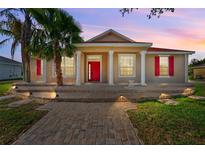 Charming single-Gathering home with red shutters and a matching red front door and a landscaped front yard at 3174 Grasmere View Pkwy, Kissimmee, FL 34746