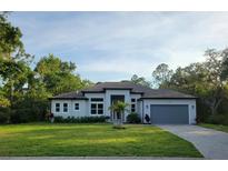 Beautiful single-story home boasts a manicured lawn, neutral paint, and an attached two car garage at 4528 Yorkshire Ln, Kissimmee, FL 34758