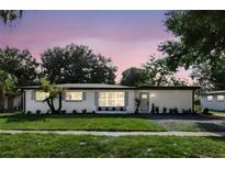 Charming single-story home with fresh white paint, landscaped yard and stylish gray window shutters at 606 Faber Dr, Orlando, FL 32822