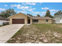 Charming single-story home with a well-manicured lawn, driveway, and a two-car garage at 622 N Goodrich Dr, Deltona, FL 32725