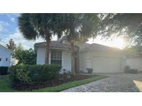 Charming home with a red tile roof and mature landscaping, including palm trees at 8532 Bay Springs Dr, Orlando, FL 32819