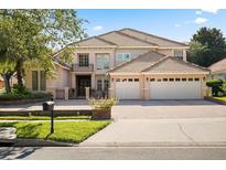 Beautiful two-story home featuring a tile roof, balcony, gated entrance, and a three-car garage at 9128 Phillips Grove Ter, Orlando, FL 32836