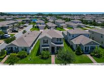 Charming two-story home featuring a well-maintained lawn, complemented by mature trees and manicured landscaping at 9971 Beach Port Dr, Winter Garden, FL 34787