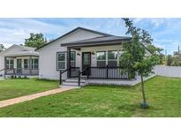 Charming home with a covered front porch, brick walkway, manicured lawn, and fresh white paint at 1050 20 St, Orlando, FL 32805